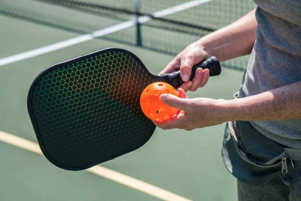 Female pickleball player in an athletic ready stance, preparing for a quick reaction shot suited for a paddle with lighter swing weight