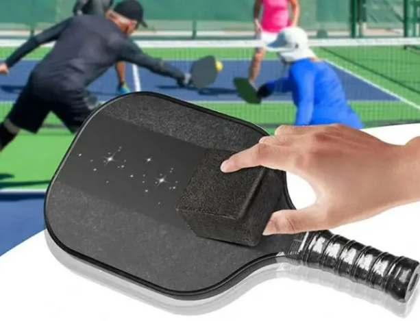 Cleaning a pickleball paddle surface with an eraser, essential for pickleball paddle maintenance.