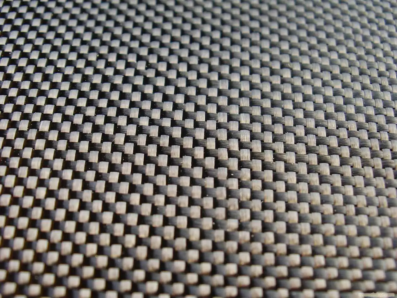 Close-up of carbon fiber weave, a strong material used in advanced pickleball paddles.