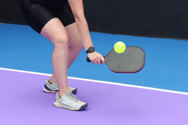 Modern black pickleball paddle with colorful accents and signature.